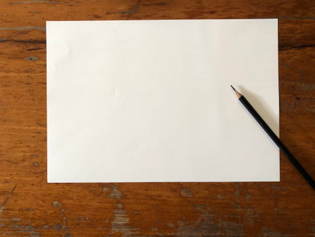 Blank white paper with pencil on wood background for your text.の写真素材