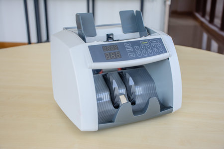 photo of cash counting machine, on the tableの写真素材