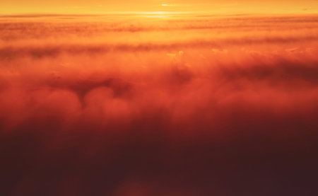 Abstract image. The setting sun beautifully painted fluffy clouds in red, orange, yellow in the...