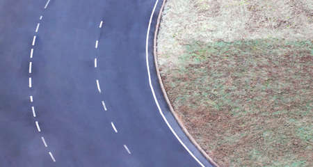Fragment of an asphalt ring road with white road markingsの写真素材