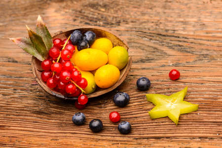 Exotic fruits on natural wood and black background.の写真素材