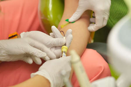 Doctor and nurse taking a blood sample from patientの写真素材