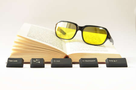 An Open Book, Computer Keys and Sunglassesの写真素材