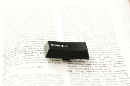 Enter computer key placed on a paper book page, close upの写真素材