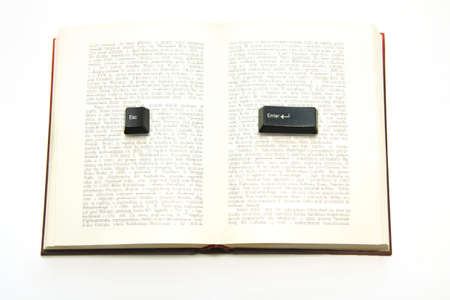 Enter and escape computer keys placed on a paper book spread, text unreadableの写真素材