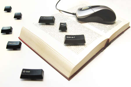 Computer mouse and keys on a book spread, dynamic, on whiteの写真素材