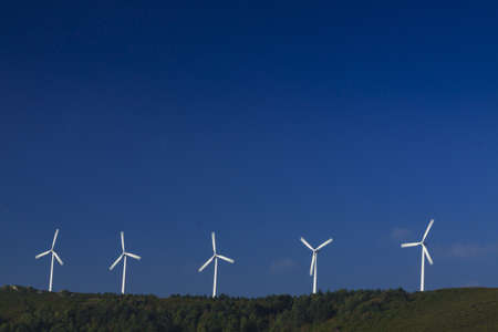 Spain, Galicia,  row of wind turbines on a hill, morning lightの写真素材
