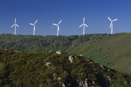 Spain, Galicia,  row of wind turbines on a hill, morning lightの写真素材