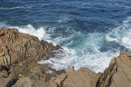 Spain, Galicia, La Coruna, Ocean Waves Breaking on the rocky coastの写真素材