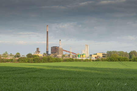 Poland, Zabrze, Biskupice coking plant seen over green field, springの写真素材