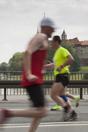 Poland, KrakÃ³w, marathon runners in motion, Wawel castle in the backgroundの写真素材