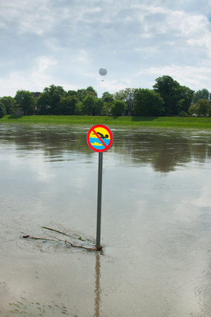 Poland, KrakÃ³w, flooded Vistula/WisÅa river embankments, no swimming sign over the water, sightseeing baloon in the backgroundの写真素材