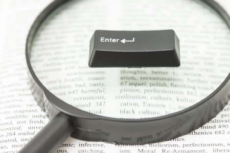 Enter Computer Key on a magnifying glass placed on a book page