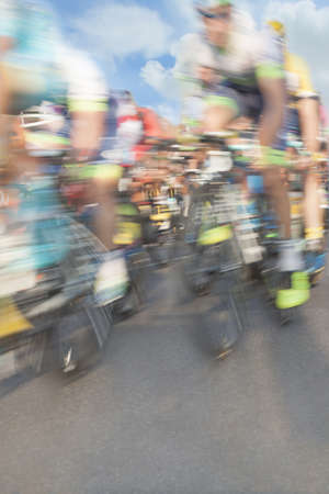Cycling race participants, motion blur, zoom in, sky in the backgroundの写真素材