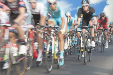 Cycling race participants, motion blur, zoom in, sky in the backgroundの写真素材