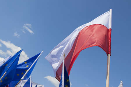Flags of Poland and European Union Flying against the sky, sunlitの写真素材