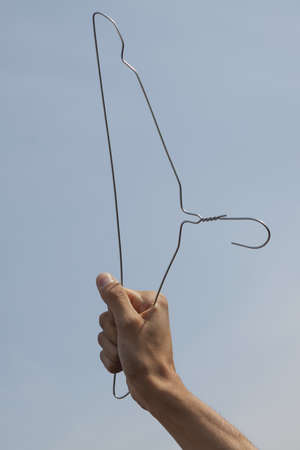 Hand of a woman holding a cloth-hanger, symbol of anti-abortion-ban protests in Polandの写真素材