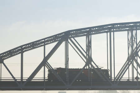 Electric locomotive on a bridge, fogの写真素材