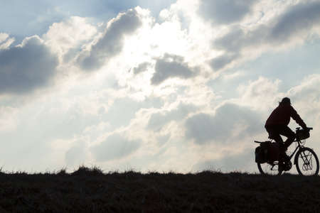 Cyclist in motion against sun and overcast sky
の写真素材
