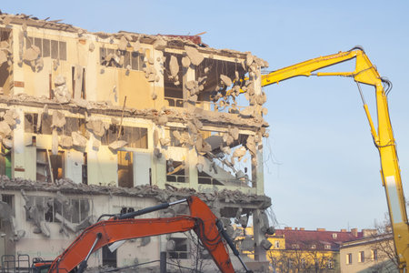 Building under demolition, sunlit, bulldozers, blue sky