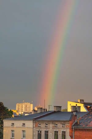 Rainbow against cloudy sky during the sunset above urban skylineの写真素材