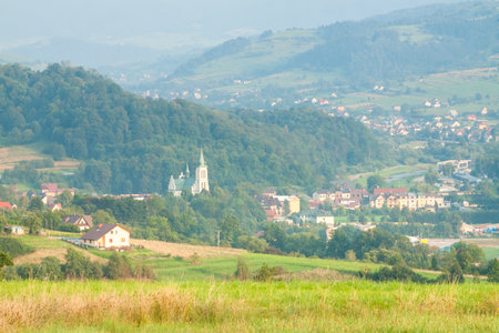 Poland, Malopolska Region, Panoramic Viev of Mszana Dolna Town and Beskid Wyspowy Mountain Range, Summer Afternoon Lightの写真素材