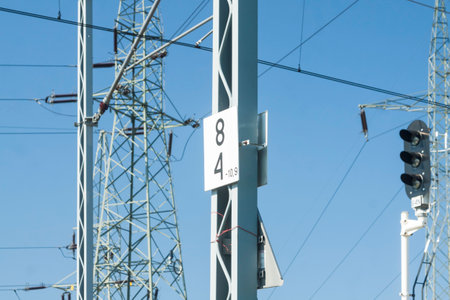 Rail Signal, Catenary Overhead Line, Power Transmission Line Tower sunlit against blue skyの写真素材