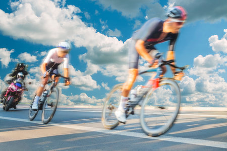 Group of Cyclists During a Race sunlit, mtion blur, overcast sky in the backgroundの写真素材