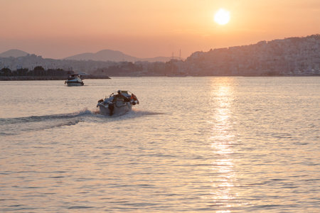 Greece, Athens, Kalithea, Faliro Marina Delta at Sunset, boat in the foreground, setting sun in the backgroundの写真素材