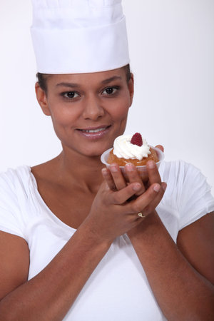 A female baker presenting a pastry.の写真素材