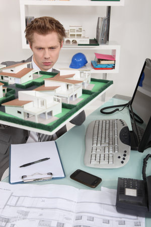 Architect inspecting model housing