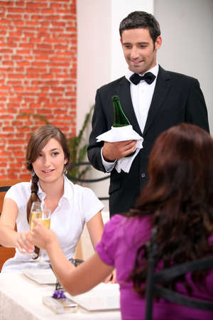 Women drinking champagne in a restaurantの写真素材