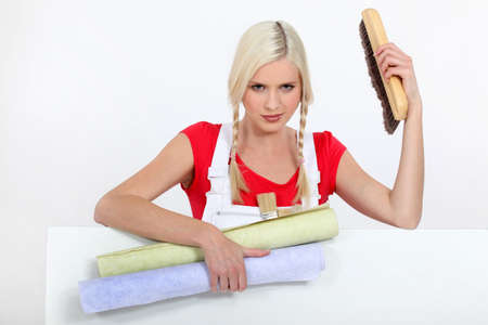 Female decorator with rolls of wallpaperの写真素材
