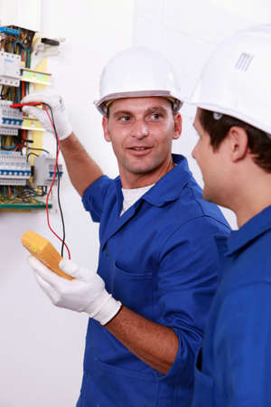 Two electricians testing fuse boxの写真素材