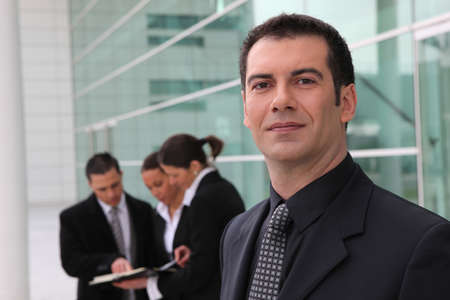 Confident businessman and business team outdoorsの写真素材