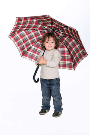 Young boy holding an umbrellaの写真素材