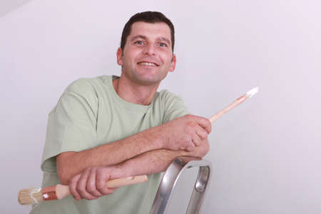 Cheerful painter on a ladderの写真素材