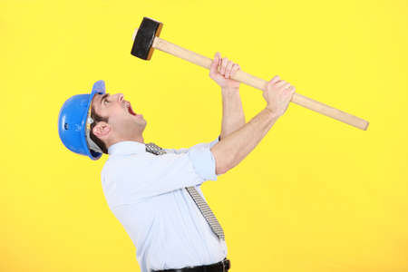 angry businessman holding a hammerの写真素材