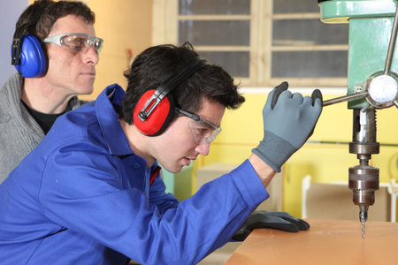 Young man using a bench drill