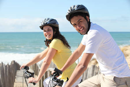 young couple riding near seafrontの写真素材