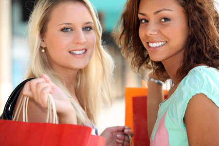 two 20 years old girls, a blonde and a metis doing shoppingの写真素材