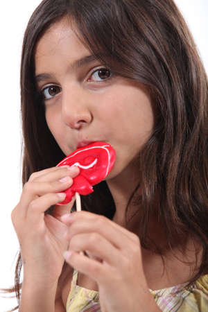 Young girl eating a lollipopの写真素材
