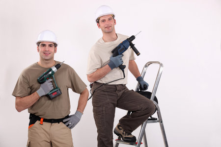 Workmen holding their electric screwdrivers