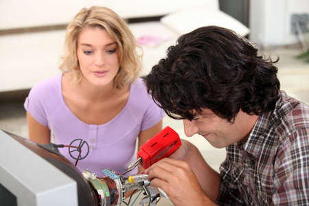 Couple repairing televisionの写真素材