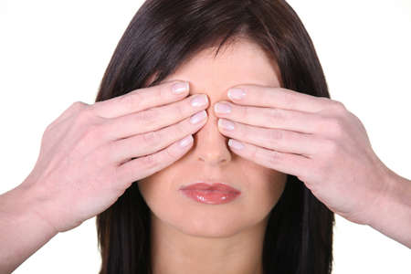 Woman covering face with handsの写真素材