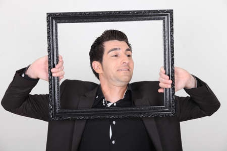 Man trying to escape a picture frameの写真素材