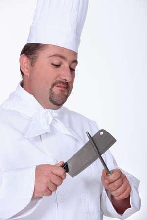 Chef sharpening meat cleaverの写真素材