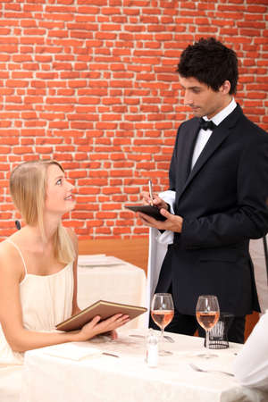 Woman ordering at a restaurantの写真素材