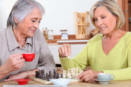 Mother and daughter playing chessの写真素材
