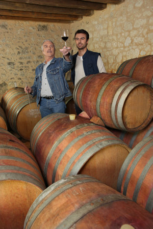 Two men tasting wine in cellar